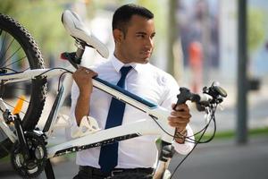 Handsome Hispanic Office Worker Carrying His Bike photo