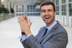 Handsome cheerful businessman clapping isolated photo