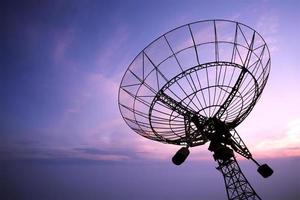 Silhouette of satellite dish antenna at sunset photo