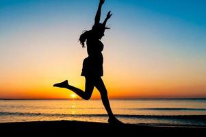 Silhouette of woman jumping in the air photo