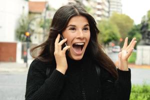 Portrait of a surprised woman talking on smart phone photo