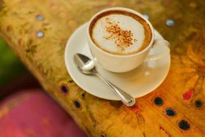 Hot Cappuccino on a Saucer with Colorful Background photo