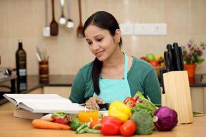 Young woman reading a cook book photo