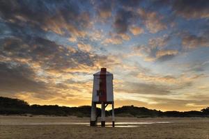 Beautiful landscape sunrise stilt lighthouse on beach photo