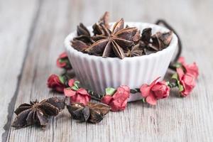 Star anise in a bowl over wooden background