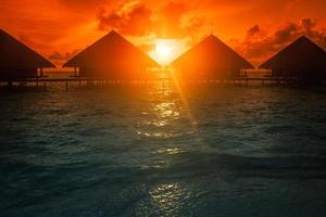 Sunset on Maldives island, water villas resort