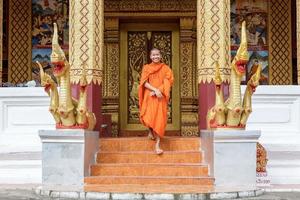 joven monje budista caminando delante del monasterio foto