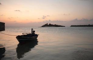 Sunset - boat, ocean and small island photo