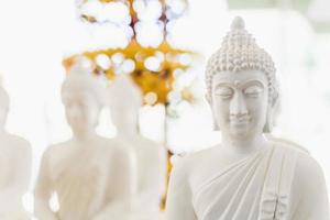 Figura blanca de Buda en bokeh. foto