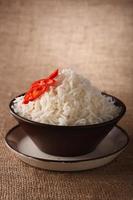 Tazón de arroz con chiles frescos sobre fondo marrón rústico,