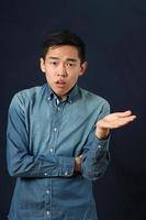 disgustado joven asiático gesticulando con una mano foto