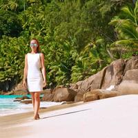 mujer con vestido en la playa en seychelles