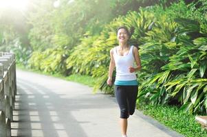young asian woman jogging in the park photo