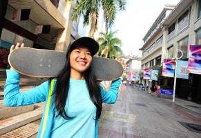 young woman skateboarder on street photo