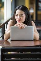 Asian woman happily using a notebook photo