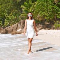 mujer con vestido en la playa en seychelles