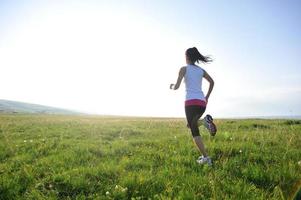 atleta corredor corriendo en pastizales foto