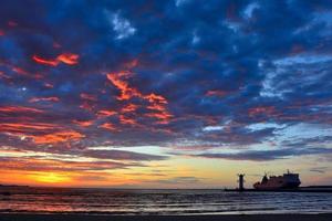puesta de sol sobre el mar con faro foto