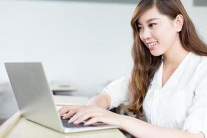 Hermosa estudiante asiática estudio con laptop en el aula