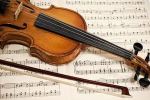 Old violin and bow on musical notes photo