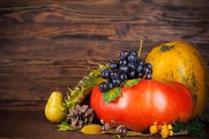 Autumnal still life with pumpkin and grapes on wooden board photo