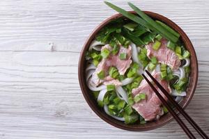 sopa vietnamita de pho bo con carne de res de cerca. vista superior foto
