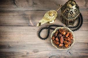lámpara de Ramadán, rosario y fechas sobre fondo de madera foto
