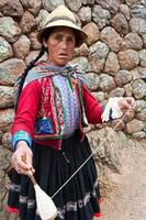 mujer peruana hilando lana, el valle sagrado, chinchero foto
