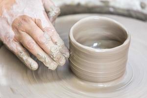 Making a pottery cup on the wheel photo