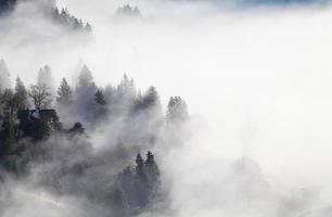 Bavarian mountain village in dense fog photo