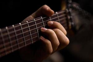 la mano del hombre tocando la guitarra