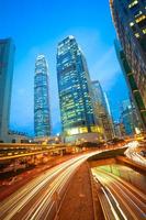 túneles de carretera senderos de luz en edificios modernos de la ciudad de hong kong