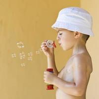 Boy Blowing Soap Bubbles photo