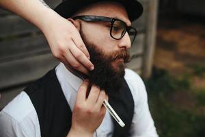 barbero afeita a un hombre barbudo