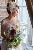 young and attractive bride sitting by the window photo