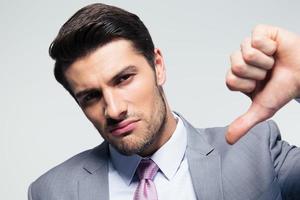 Businessman showing thumb down sign photo
