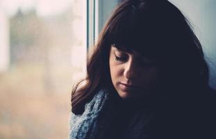 Young woman longs near a window photo