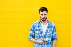 young handsome man with headphones on yellow wall photo
