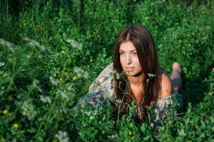 linda chica entre hierba verde y flores foto