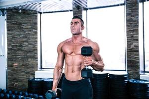 Muscular man workout with dumbbells photo
