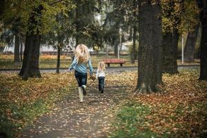 madre con hija en el parque otoño