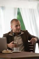 Business man resting at cafe and listening music using headphones photo