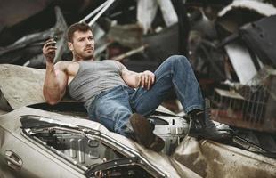 The man taking a rest on a car wreck