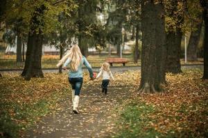 madre con hija en el parque otoño