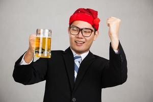feliz empresario asiático con sombrero de fiesta emborracharse con cerveza foto