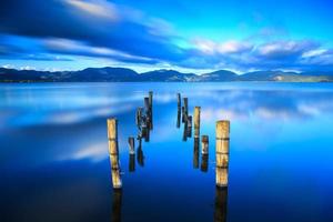 muelle de madera, embarcadero permanece en un lago azul puesta de sol, cielo