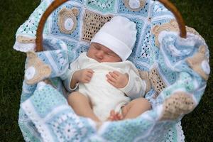 newborn baby is lies on the blue cover in basket photo