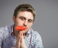 Portrait of man holding red flower photo