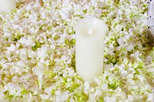 The big white candle in a wreath from artificial flowers photo