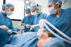 equipo de cirujanos que opera en el estómago de un paciente foto